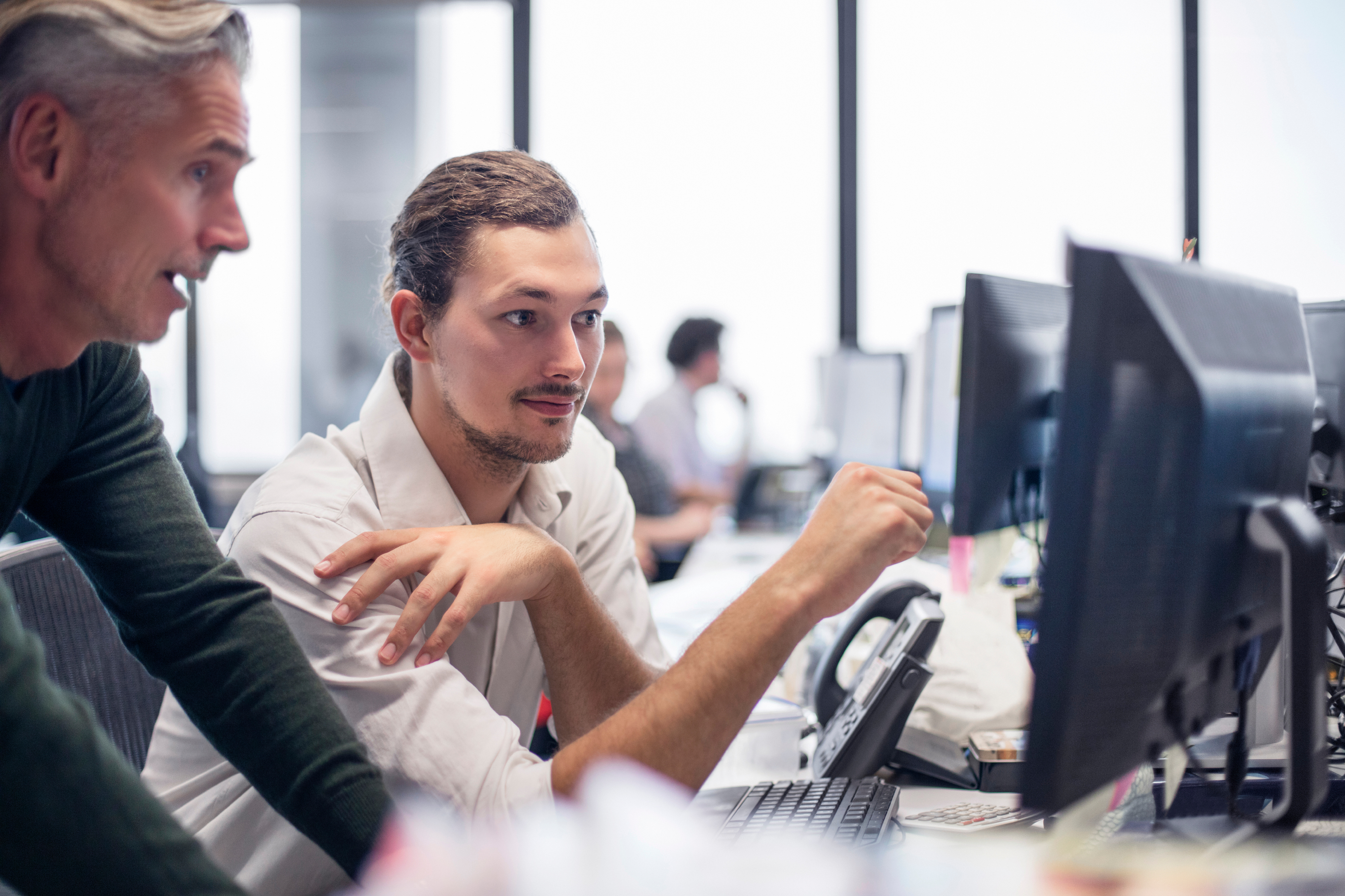 Senior colleague mentoring a consultant at their desk — candidate photo for Colibrí Sky